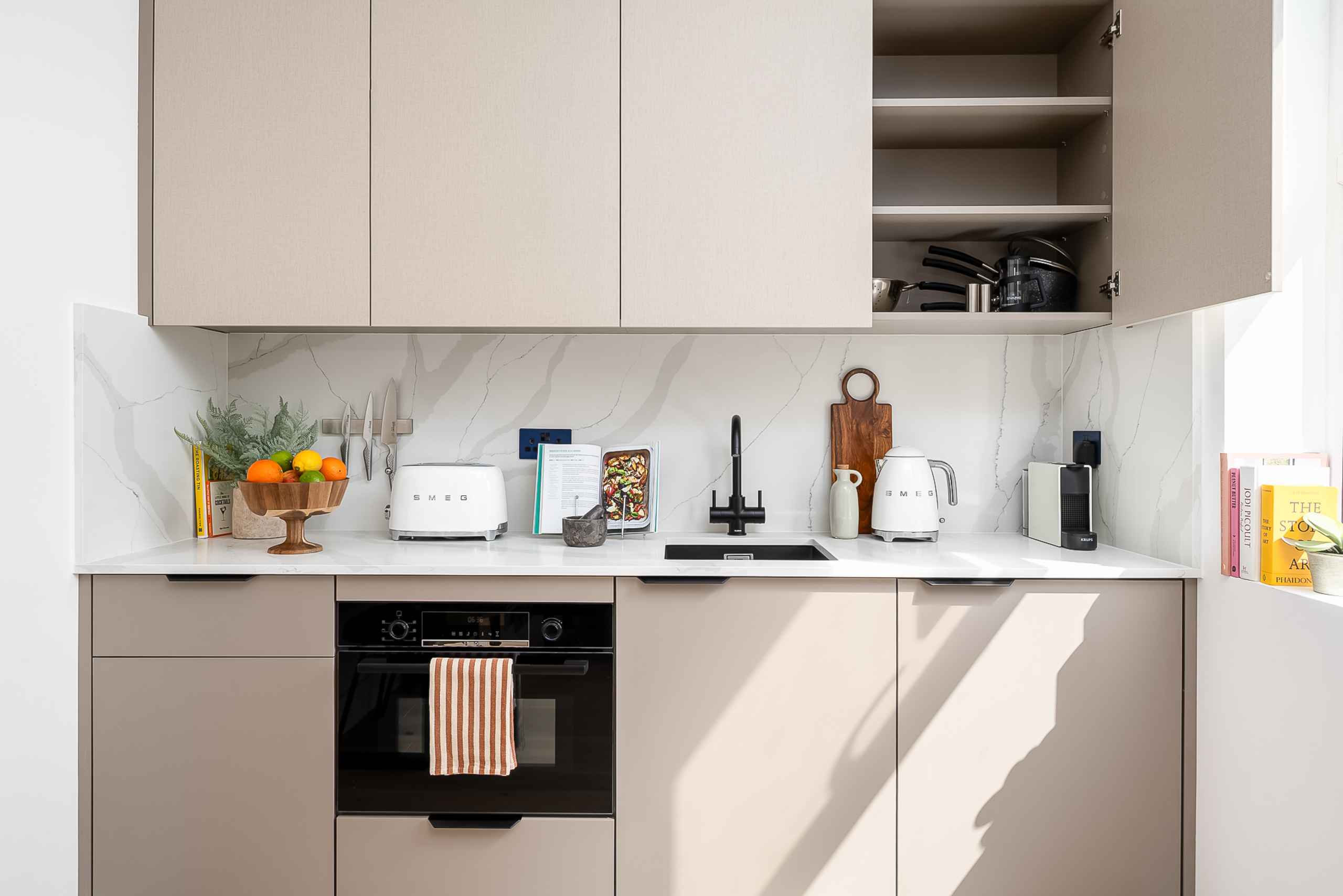 Minimalist white kitchen with integrated appliances in studo